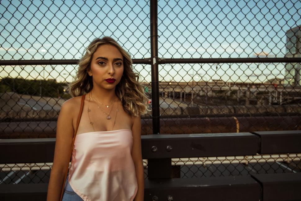 Free Image of Young woman near industrial backdrop at dusk 