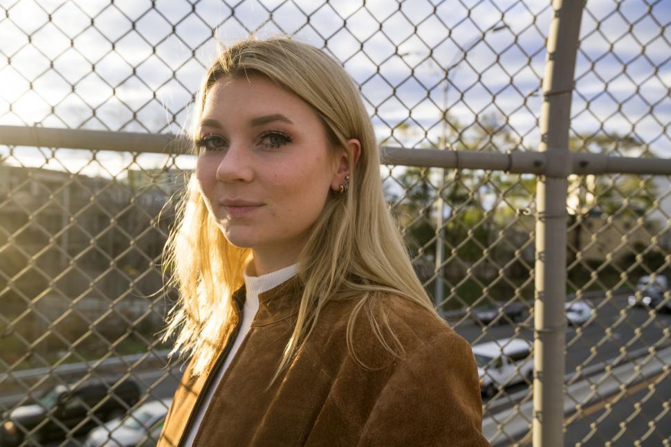 Free Image of Woman by fence during golden hour 