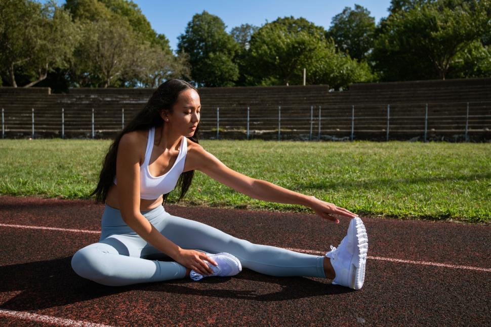 Free Image of Athlete stretching on a running track 
