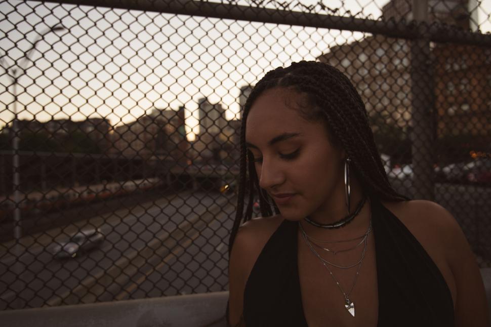Free Image of Dusk portrait of woman with urban backdrop 