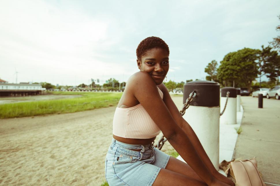 Free Image of Young woman sitting by a marina 