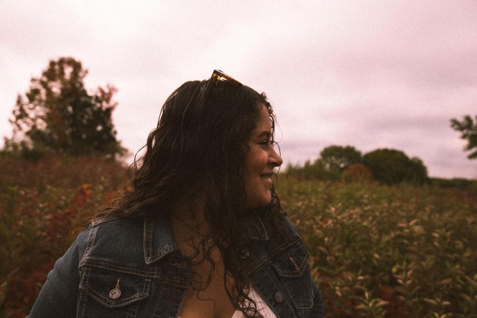 Free Image of Woman in denim overlooking serene autumn fields 