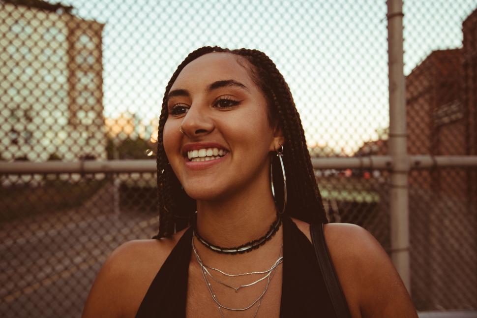 Free Image of Happy woman laughing with urban backdrop 