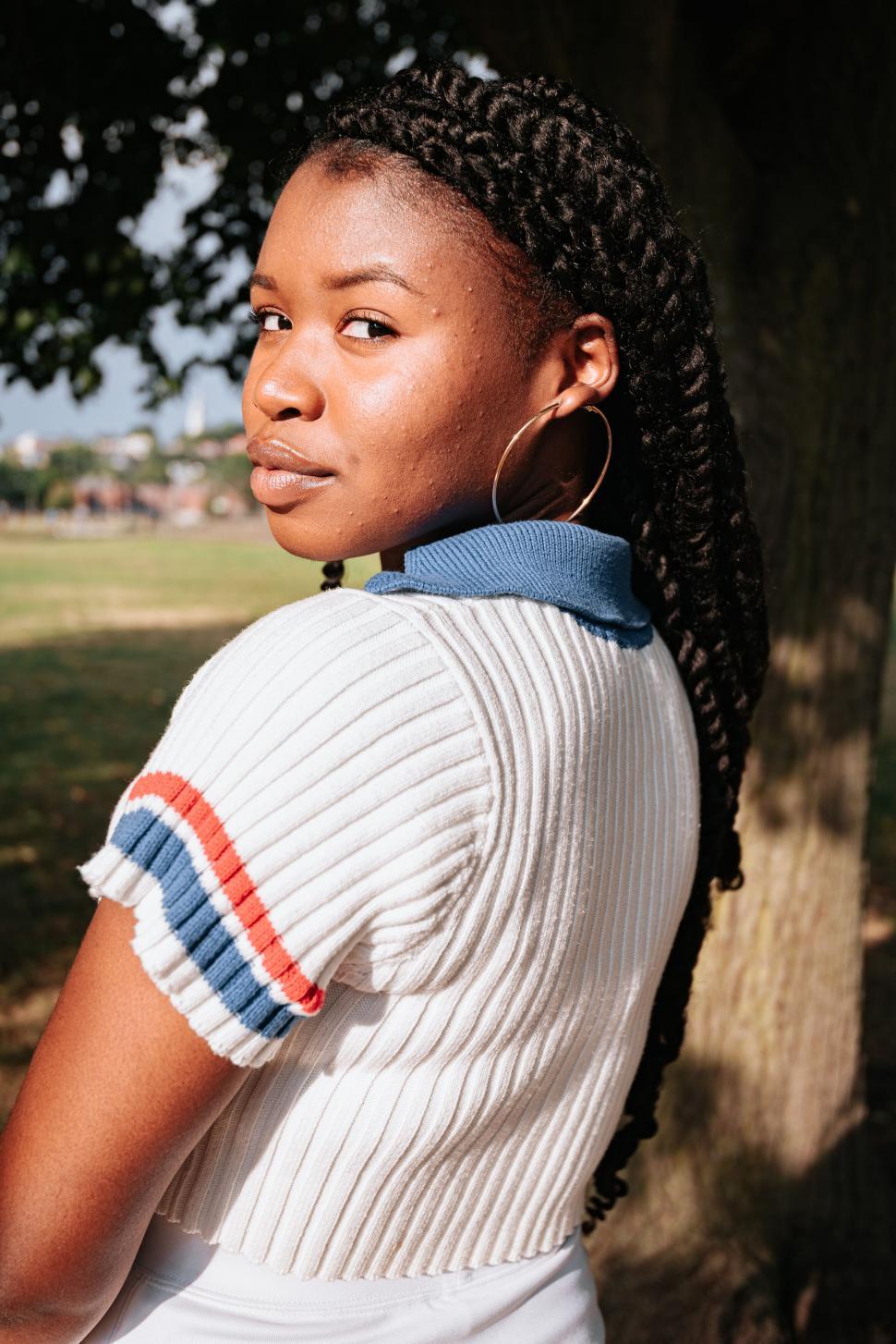 Free Image of Portrait of woman leaning against tree 