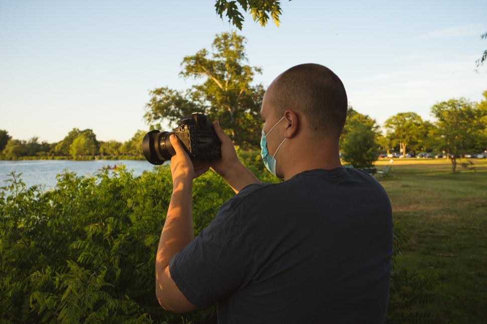 Free Image of Photographer capturing serene lakeside view 