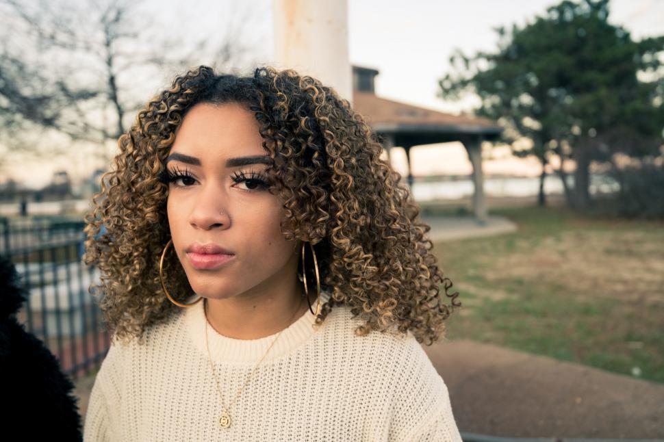 Free Image of Portrait of young woman with curly hair outdoor 