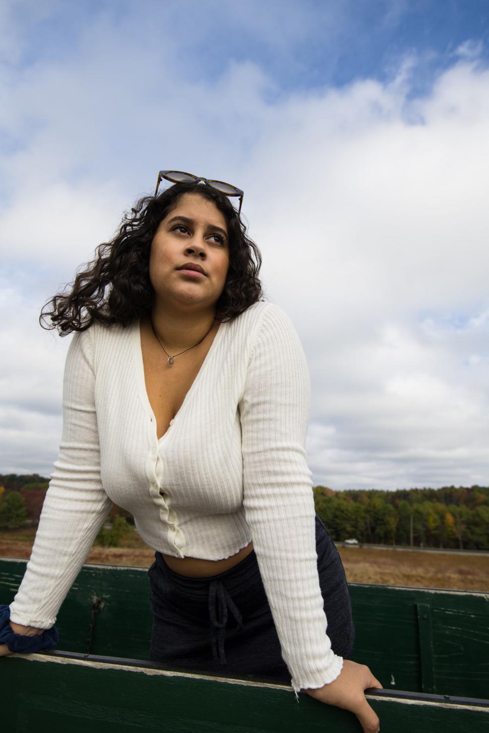 Free Image of Curly-haired woman looking thoughtful 