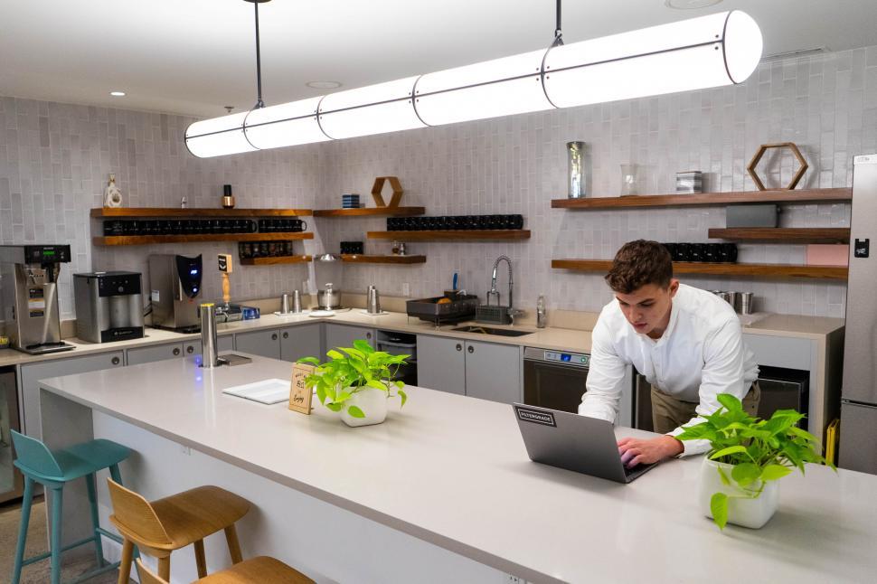 Free Image of Modern kitchen interior with a working man 