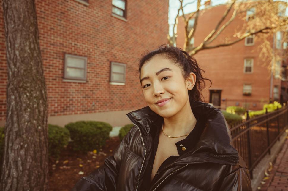 Free Image of Smiling young woman outdoors with urban backdrop 