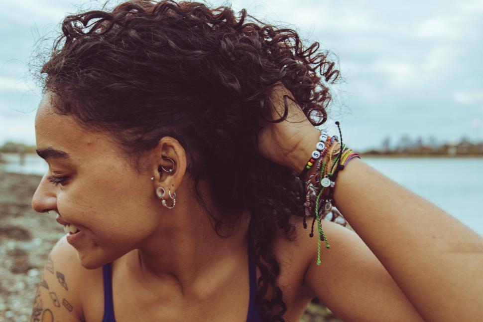Free Image of Woman adjusting hair by the waterfront 