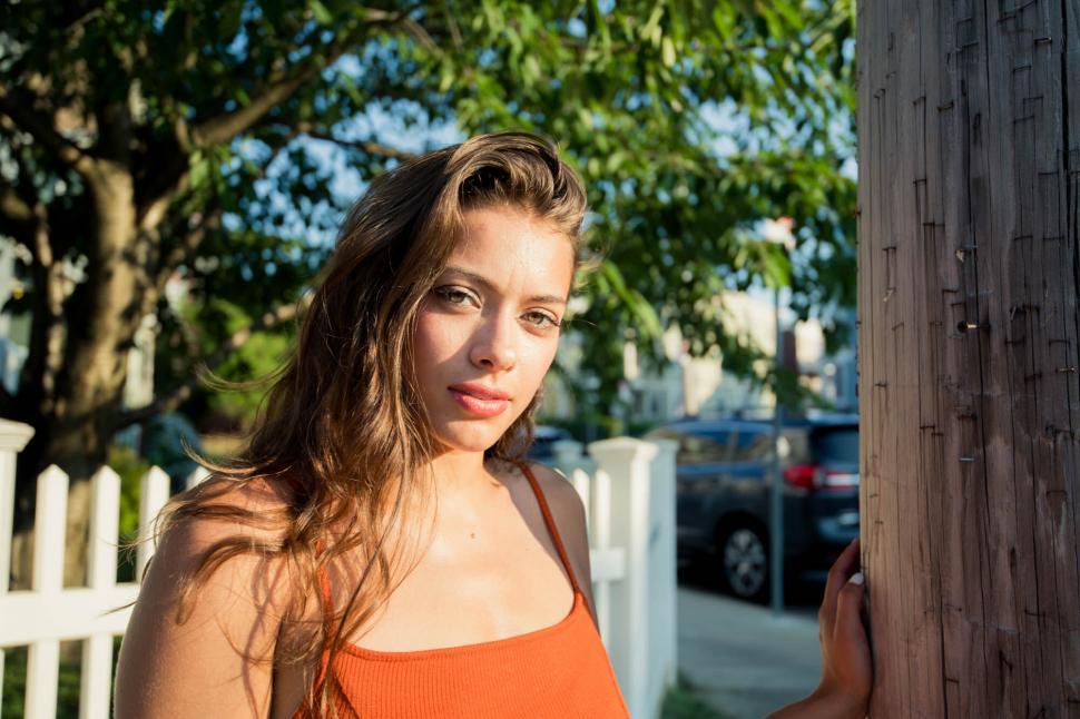 Free Image of Young woman near wooden pole 