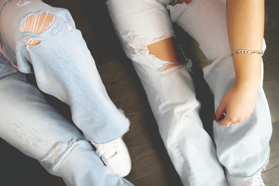 Free Image of Woman in distressed denim jeans and sneakers 