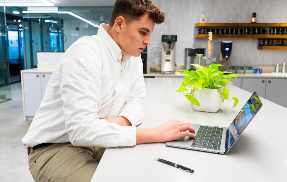 Free Image of Man in white shirt working on laptop 