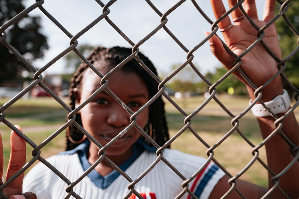 Free Image of Person behind a fence looking out unsettled 