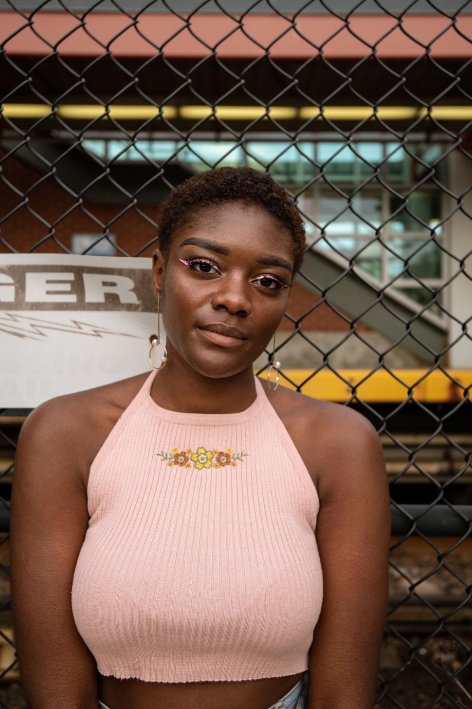 Free Image of Close-up of Woman in Front of Fence 