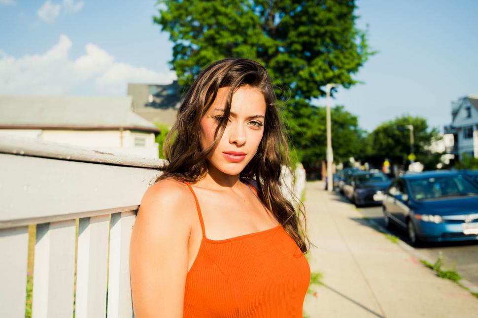 Free Image of Woman posing in sunlight on urban street 