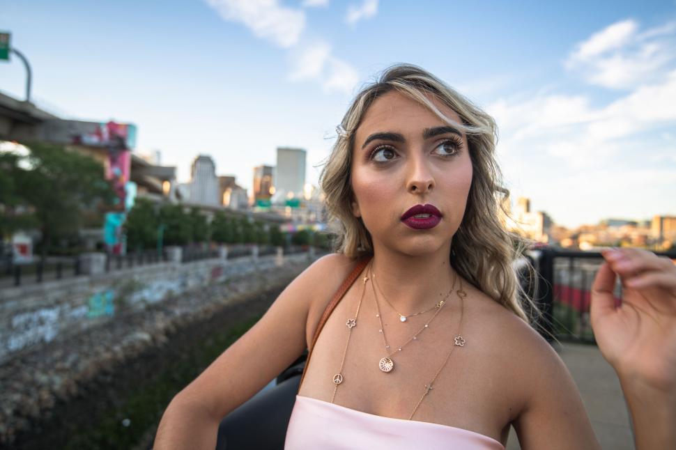Free Image of Fashionable woman with a city backdrop at dusk 