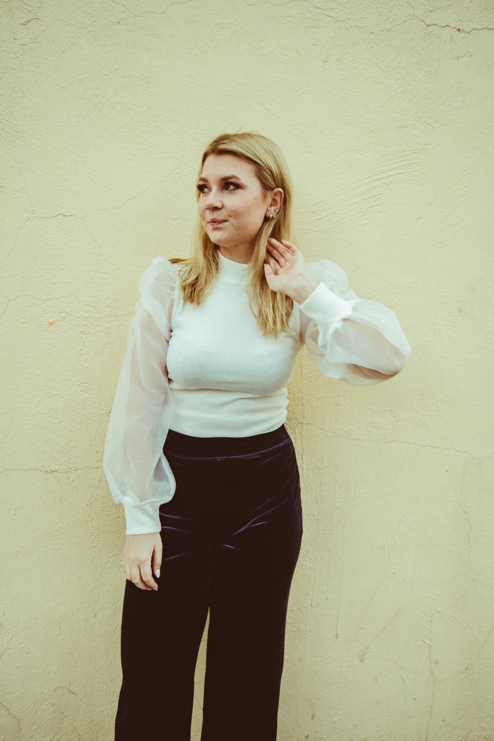 Free Image of Elegant woman posing against yellow wall 