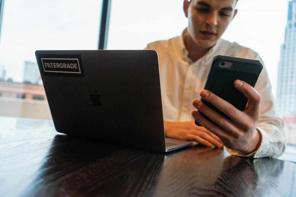 Free Image of Young man multitasking with tech gadgets 
