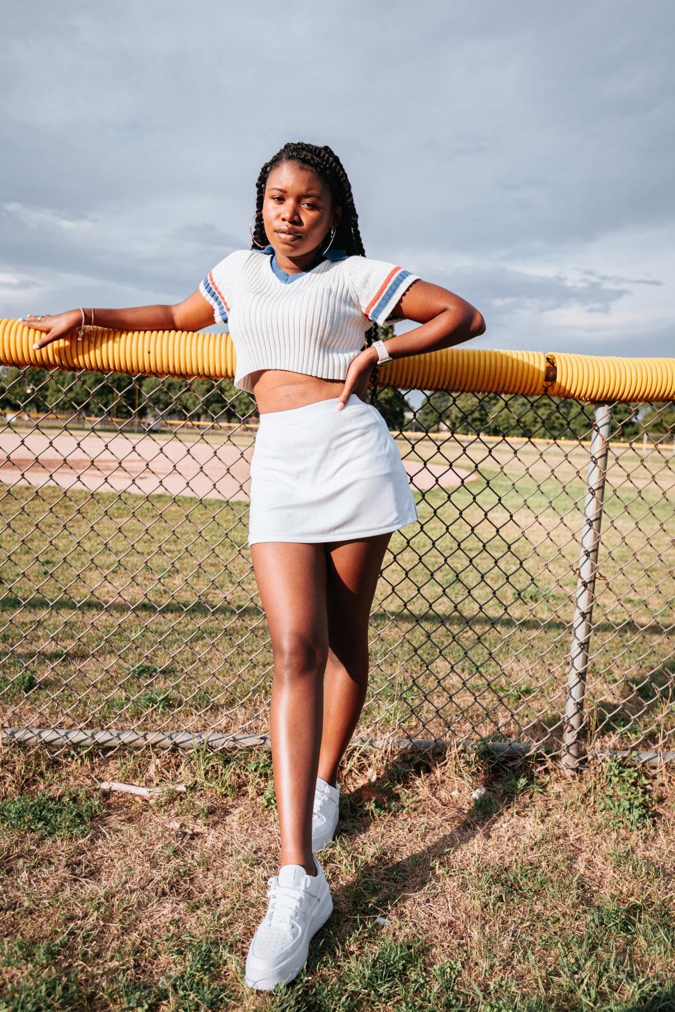 Free Image of Confident woman by yellow fence 
