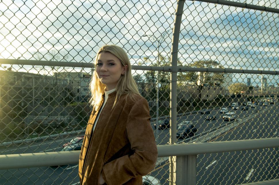 Free Image of Woman in front of chain link fence 
