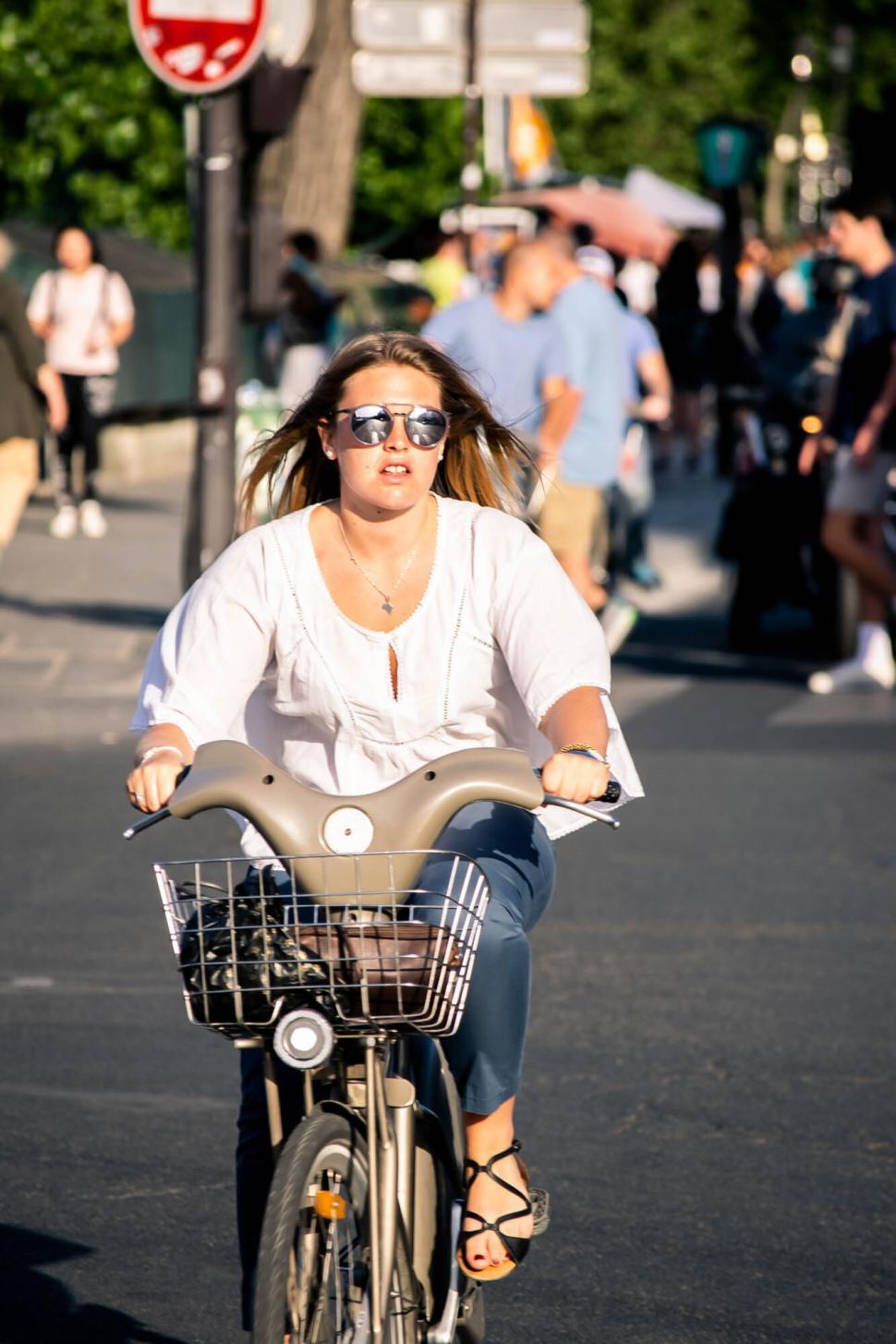Free Image of Unidentifiable woman cycling on city street 