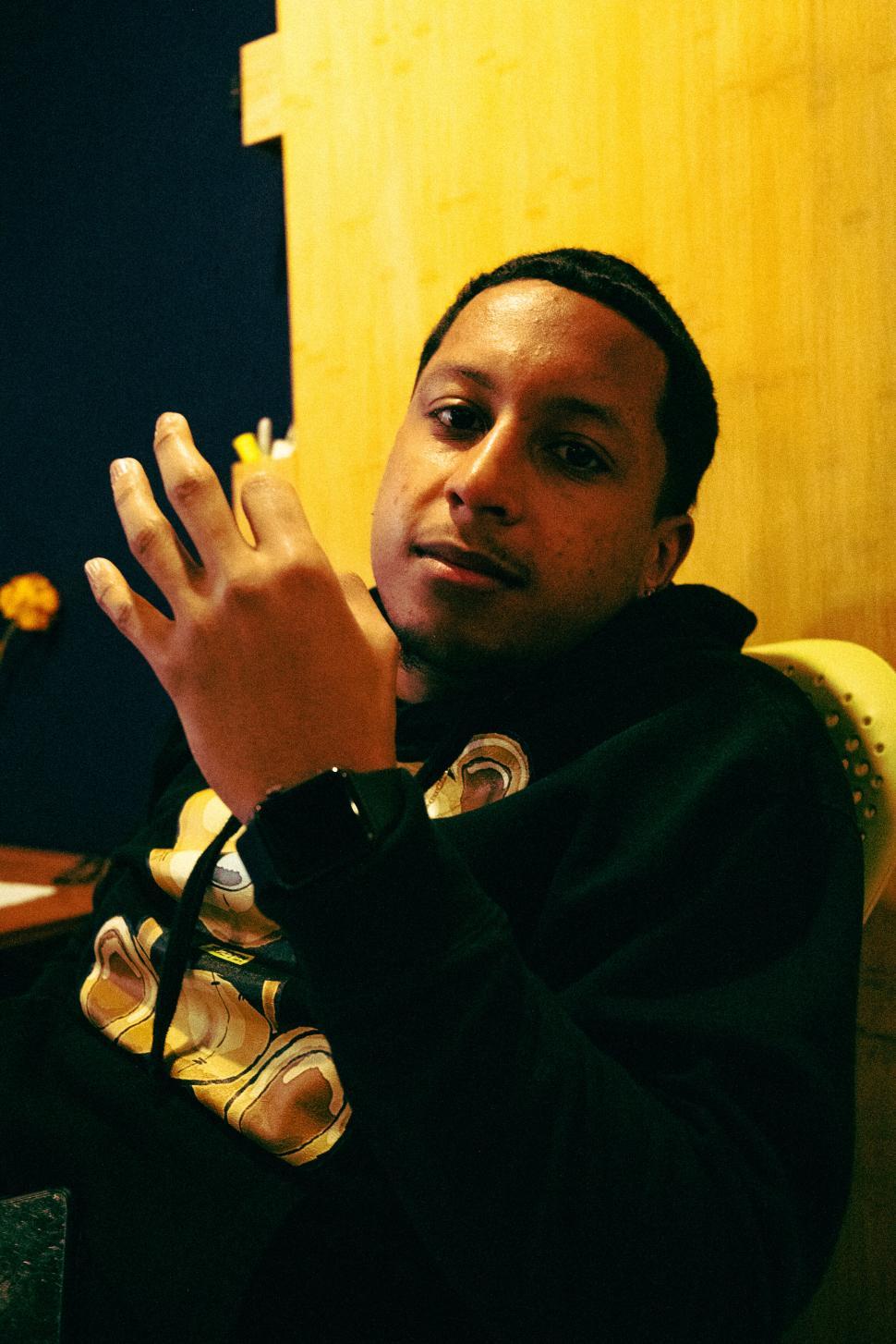 Free Image of Casual man posing indoors with hand gesture 
