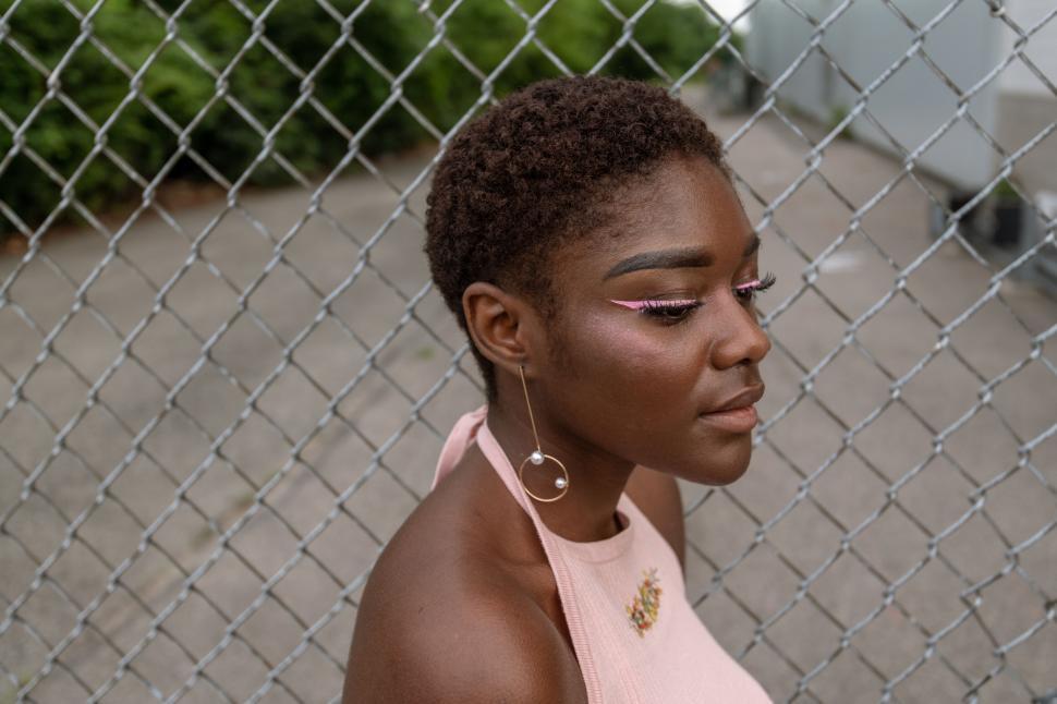 Free Image of Close-up of a woman by the fence 