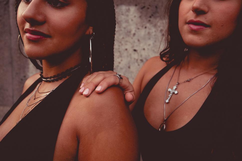 Free Image of Two women holding hands with obscured faces 