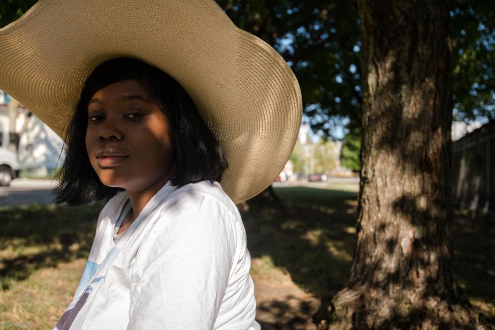 Free Image of Woman with hat sitting in the shade 