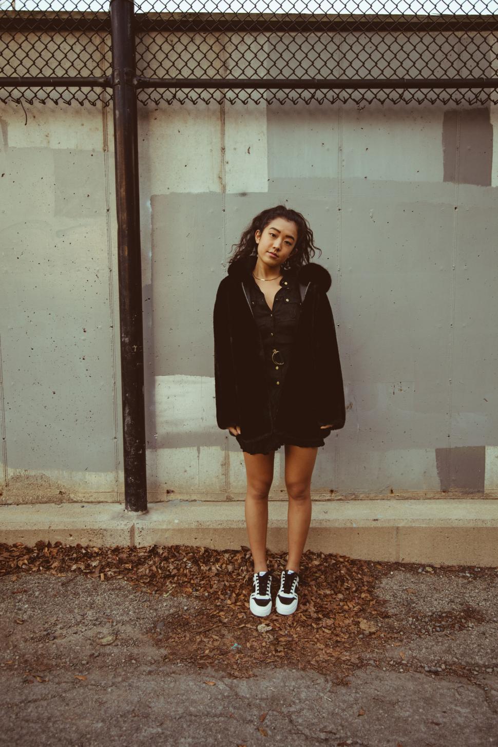 Free Image of Woman in black attire against wall 