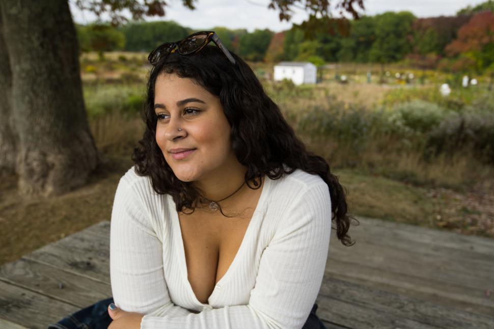 Free Image of Curly-haired woman smiling in nature 