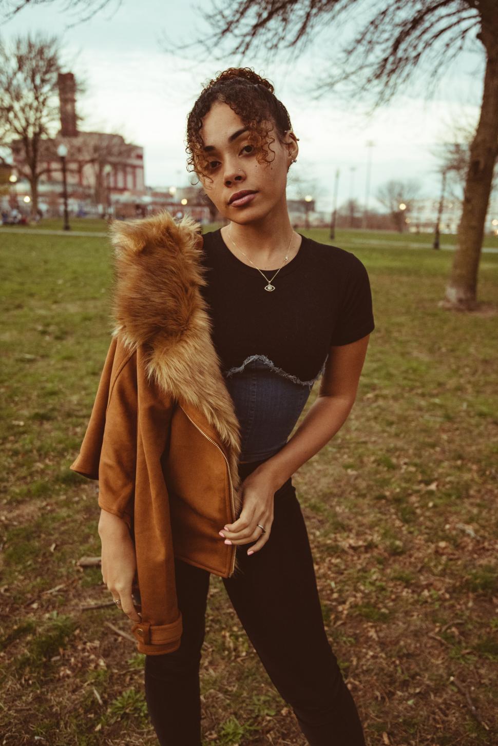 Free Image of Young woman with fur-collared coat outdoors 