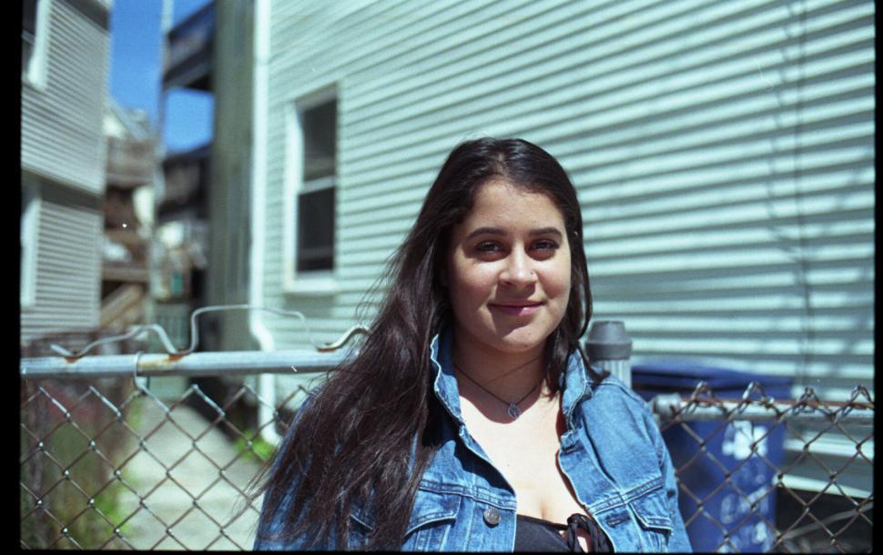 Free Image of Teen girl smiling in front of a suburban home 