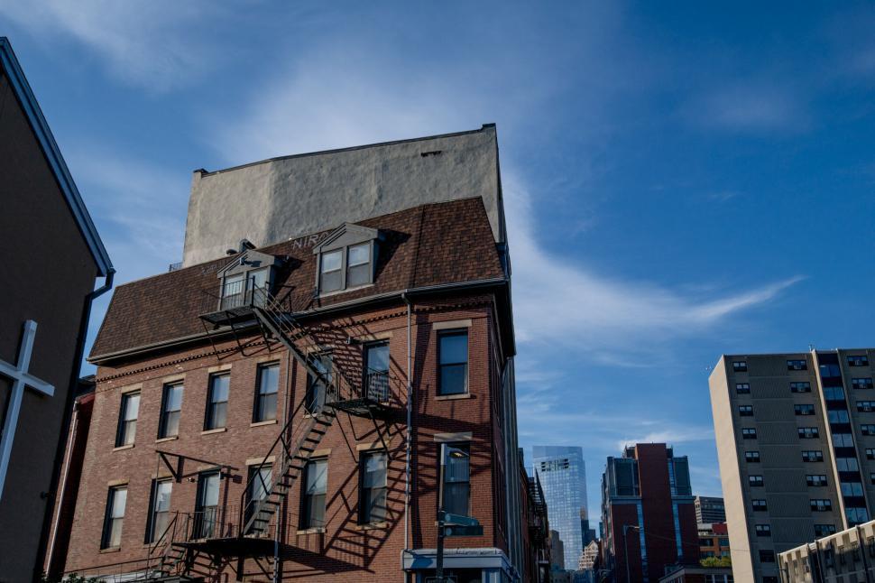 Free Image of Red brick building with fire escape against sky 
