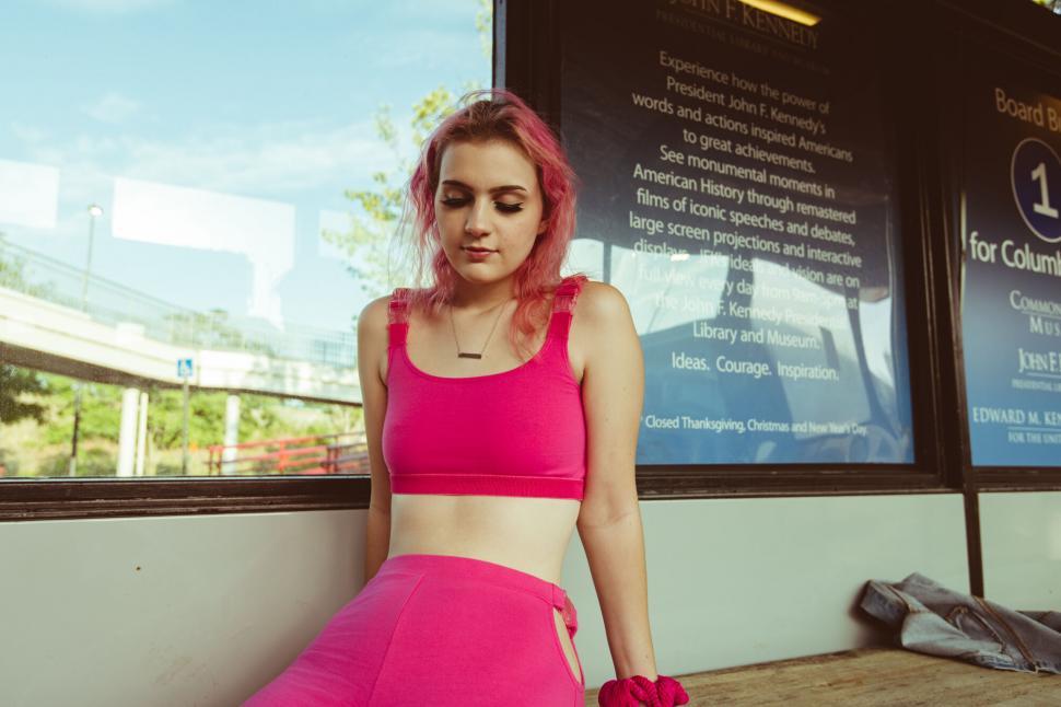 Free Image of Pink-haired woman at urban bus station 