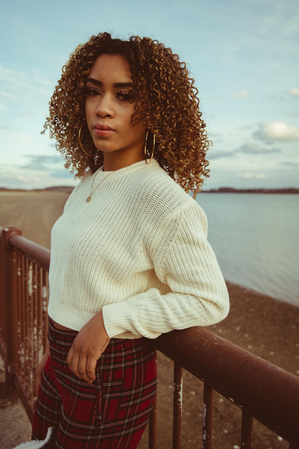 Free Image of Curly-haired woman by the lakeside 