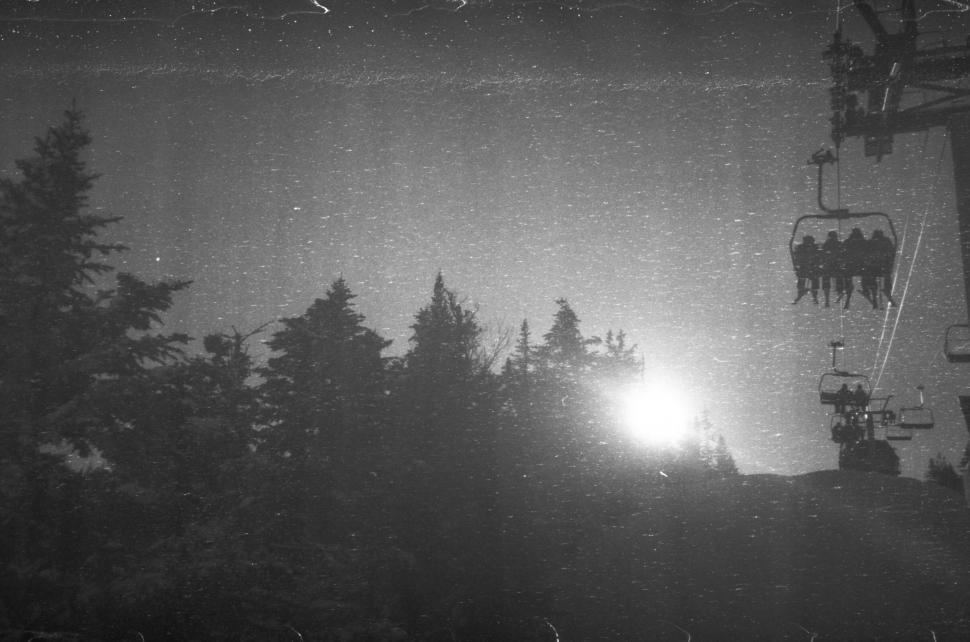 Free Image of Vintage chairlift over snowy forests scene 