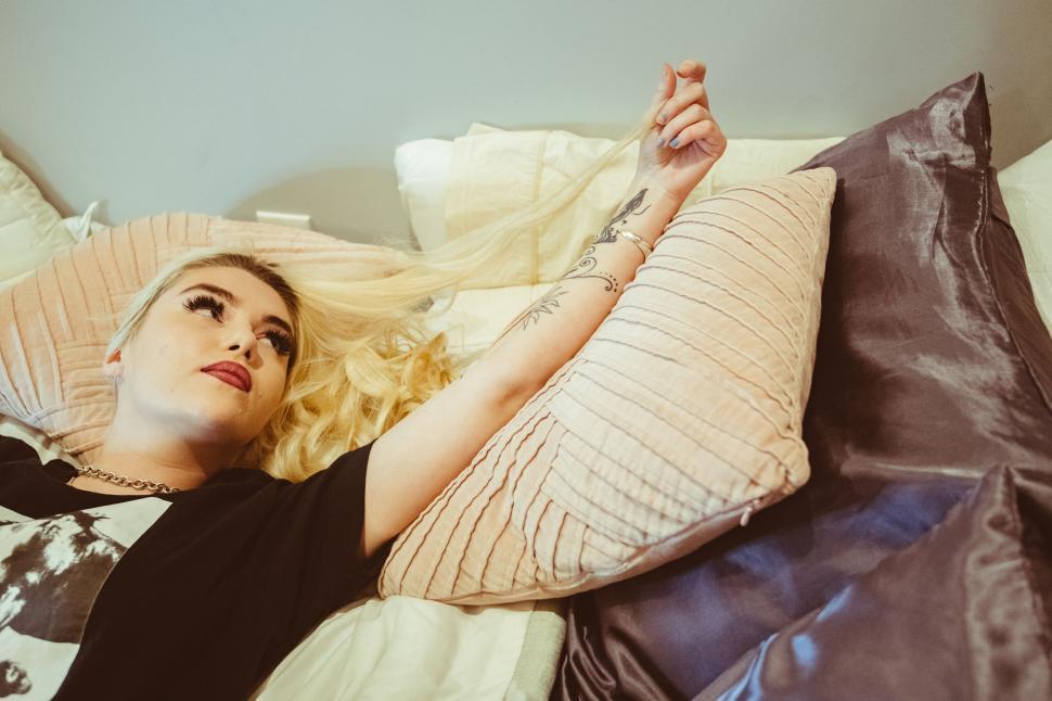 Free Image of Woman lying on bed looking upwards 