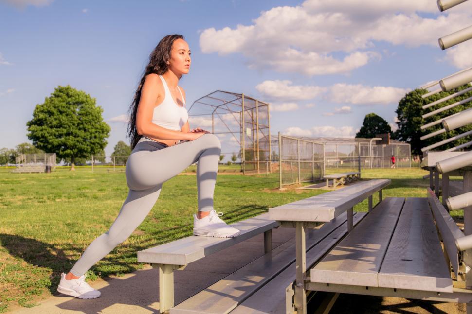 Free Image of Woman stretching on stadium bleachers 