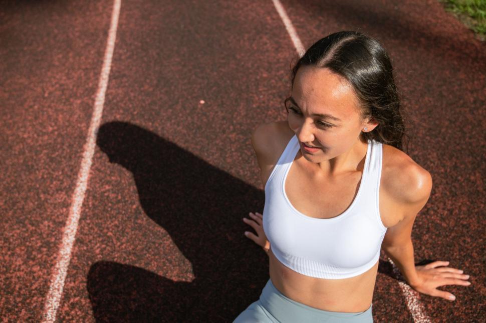 Free Image of Athlete resting on running track 