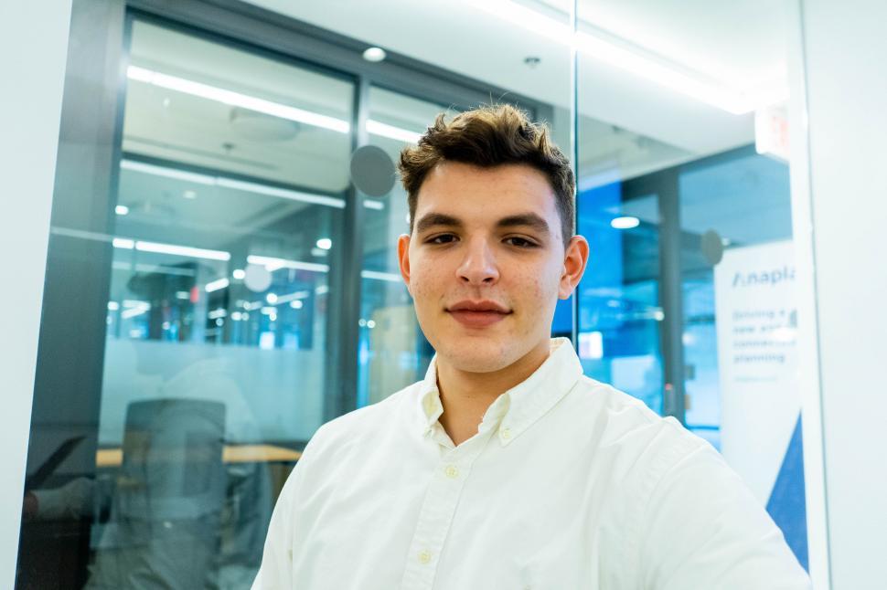 Free Image of Young man in white shirt indoors smiling 