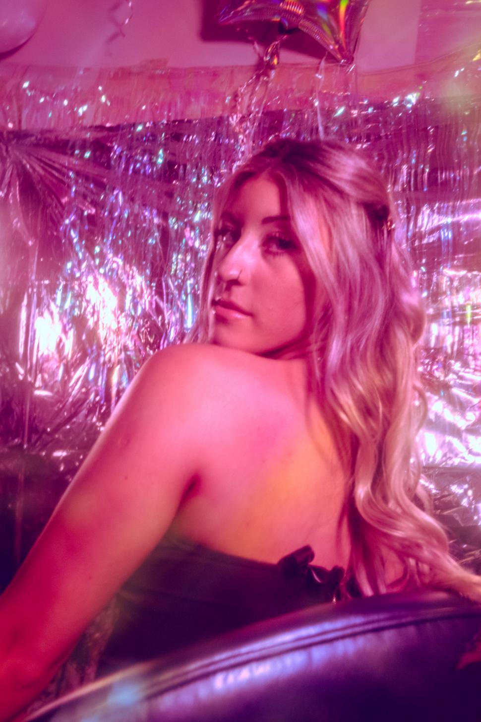 Free Image of Woman in party setting with purple tones 