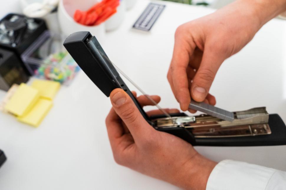 Free Image of Man loading staple gun casually at work 
