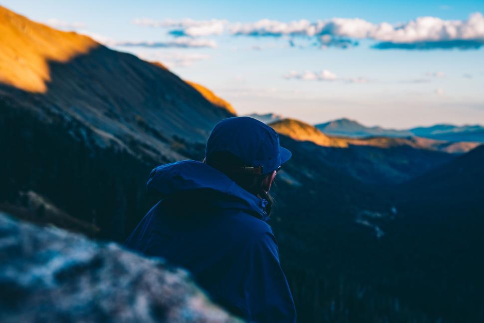 Free Image of Hiker looking over mountain landscape at dusk 