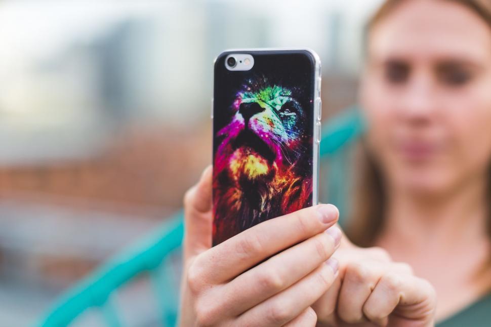 Free Image of Colorful phone case with woman in background 