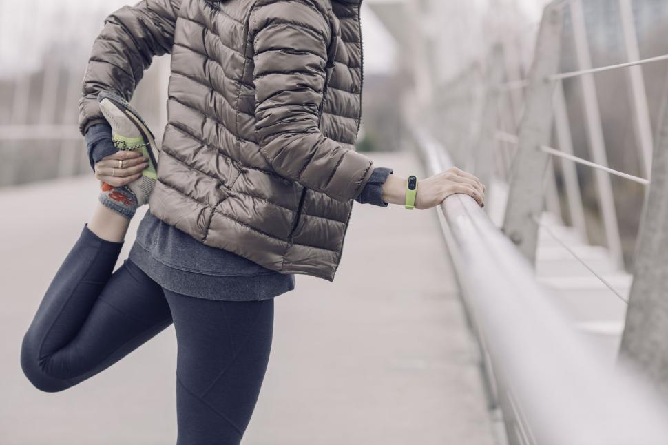 Free Image of Athlete stretching her calf on a bridge 