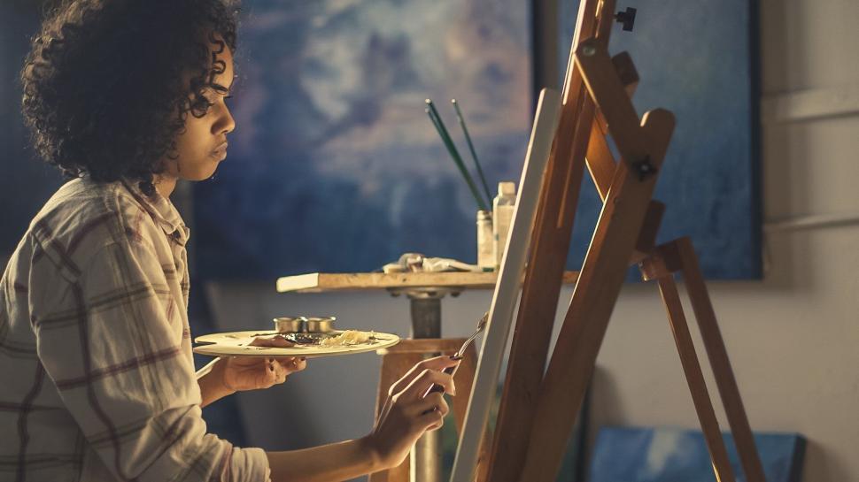 Free Image of Artist painting on easel in studio 
