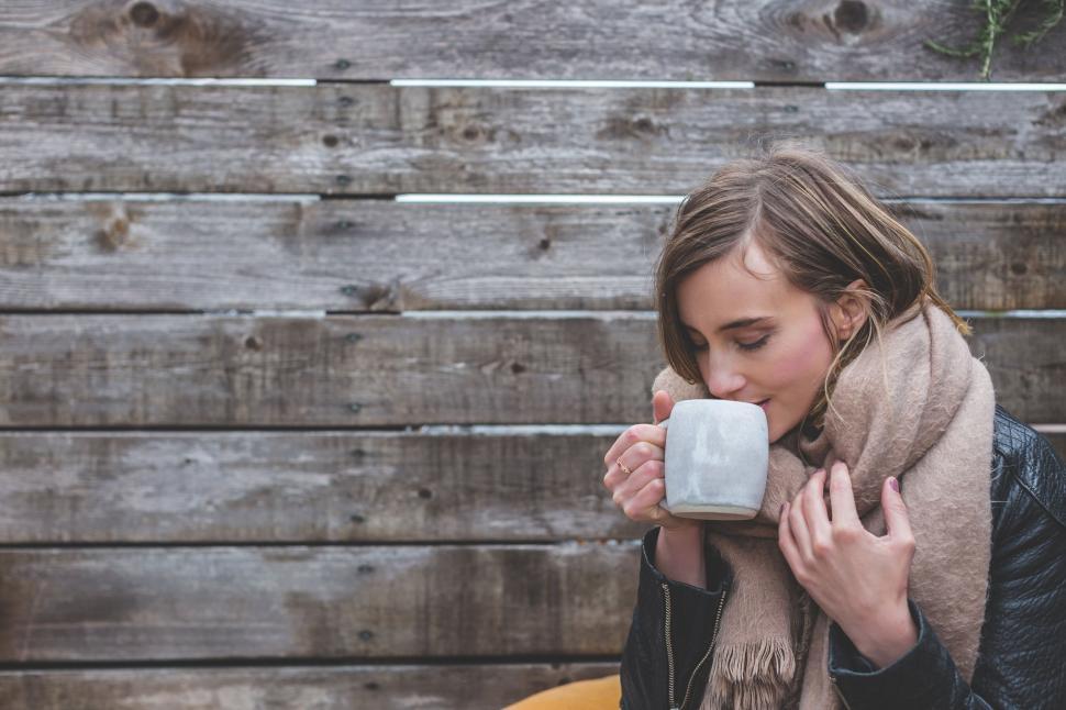 Free Image of Woman enjoying a warm drink outside 