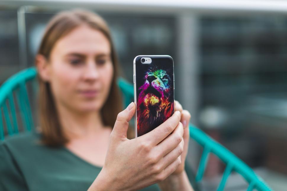 Free Image of Person holding smartphone with colorful case 